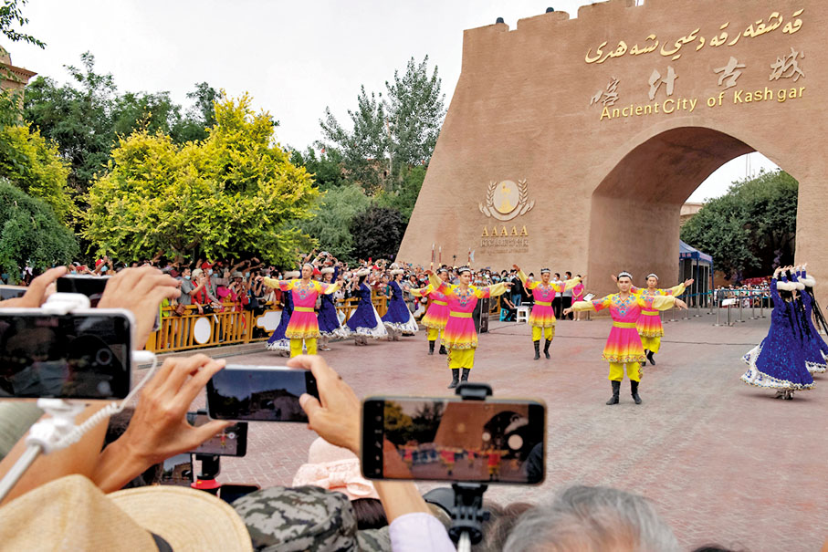 ◆喀什古城景區舉行入城儀式，工作人員以歌舞表演歡迎八方遊客。 新華社
