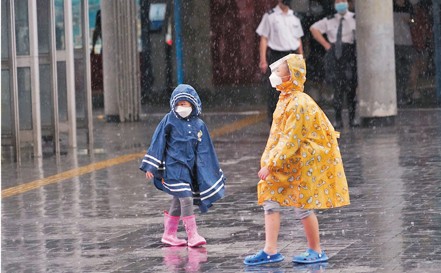 ◆小朋友在雨中嬉戲，無意避雨。 香港文匯報記者  攝