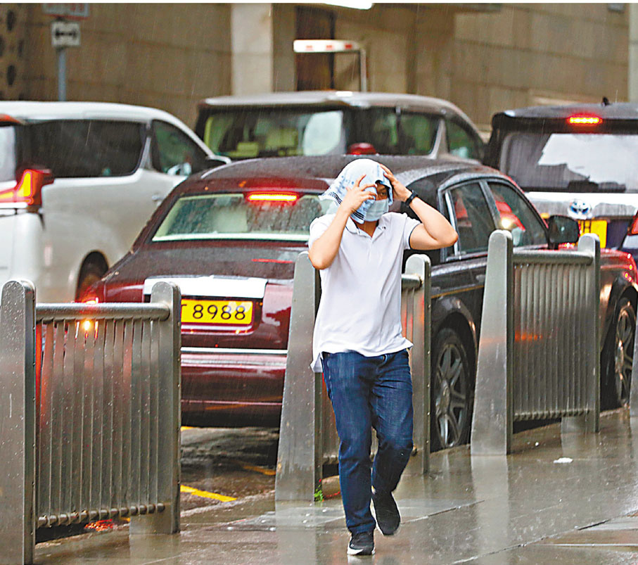 ◆有市民無帶遮，用毛巾包頭擋雨。香港文匯報記者  攝
