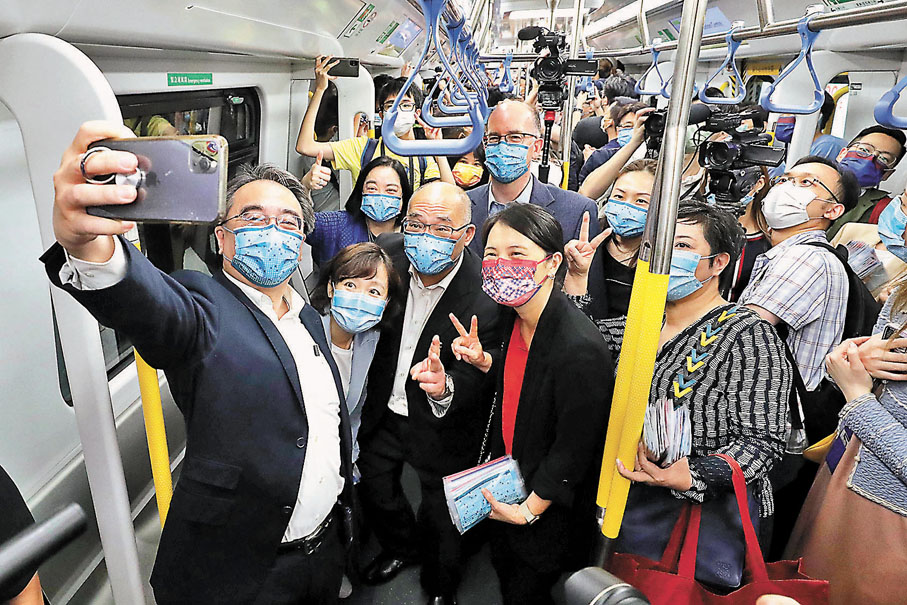 ◆ 金澤培和一眾鐵路迷在會展站頭班過海東鐵列車開出時自拍留念。  香港文匯報記者 攝