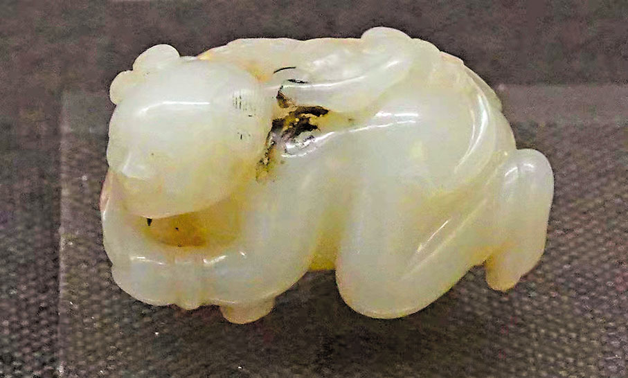 ◆清代白玉鏤雕持靈芝臥童，為清代女子配飾。