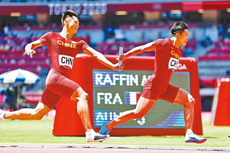 ◆在東奧田徑男子4×100米接力決賽，謝震業（左）與蘇炳添交接棒。 資料圖片