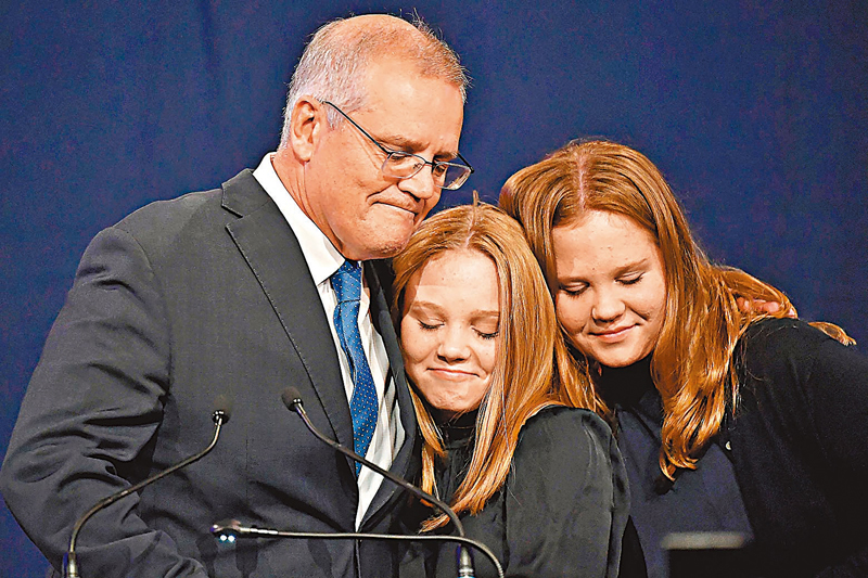 ◆莫里森承認落敗，獲兩名女兒相擁安慰。法新社