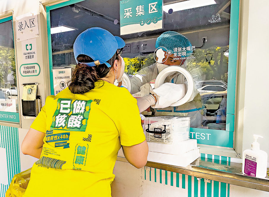 ◆5月23日，市民在北京市朝陽區望京街道的一處常態化核酸檢測採樣點進行採樣。 中新社