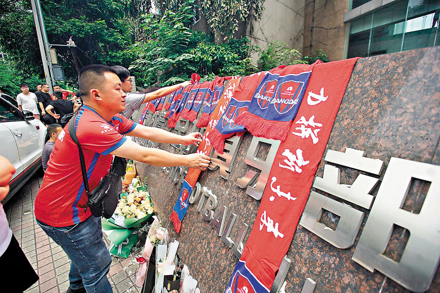 ◆重慶球迷得知球隊解散後，紛紛在俱樂部門前「悼念」。 法新社