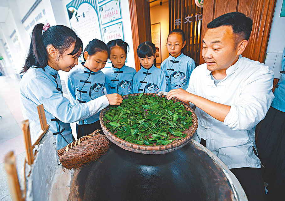 ◆杭州市富陽區里山鎮中心小學開設少兒茶藝傳習班，老師指導學生體驗傳統炒茶。