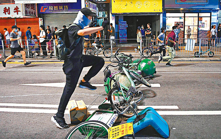 ◆修例風波期間暴徒四處非法集結及堵路縱火。圖為2019年10月有黑衣暴徒在元朗一帶非法集結及用單車和小巴站牌等堵路。資料圖片