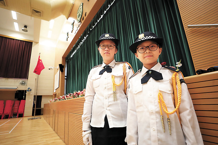 ◆升旗隊隊長梁紫滕（右）與持旗手紀潔怡（左）。 香港文匯報記者  攝
