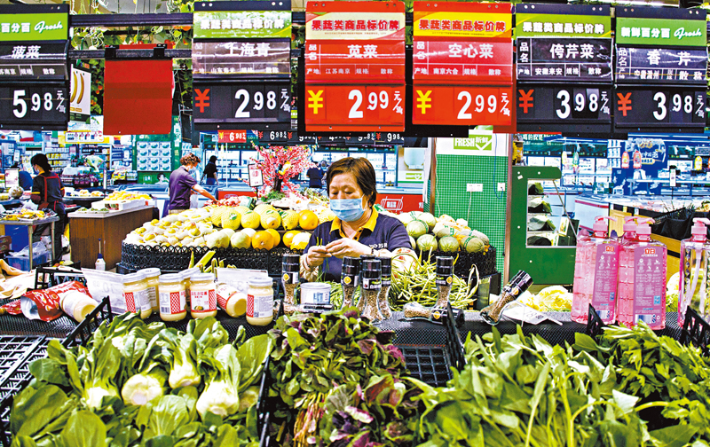 ◆5月份，內地居民消費價格指數同比上漲2.1%，漲幅與4月相同。圖為 6月10日，南京一家超市的營業員在整理蔬菜。 新華社