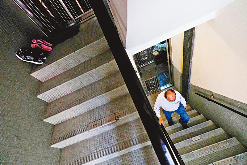 ◆長者爬樓梯可謂一步一艱辛。 香港文匯報記者  攝