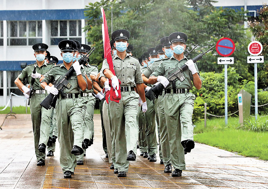 ◆升旗手及護旗人員在《歌唱祖國》的音樂聲下踏着正步前進。 香港文匯報記者  攝
