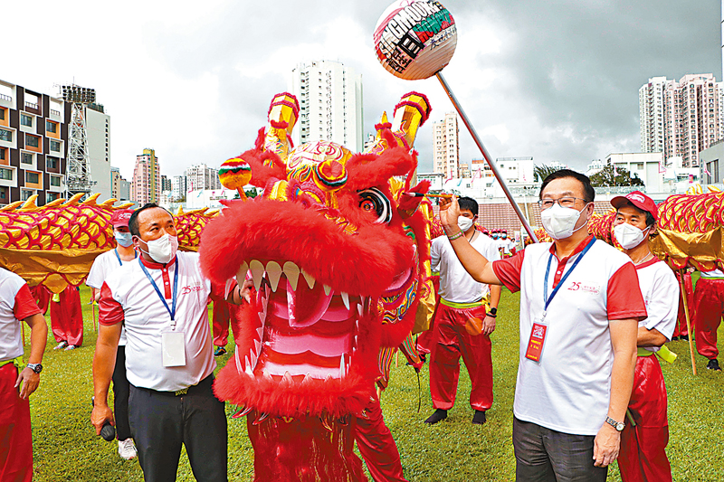 ◆  何靖（持筆者）為金龍點睛。 香港文匯報記者  攝