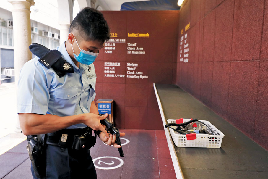 ◆ 盧俊成領完槍支後細心檢查。香港文匯報記者  攝
