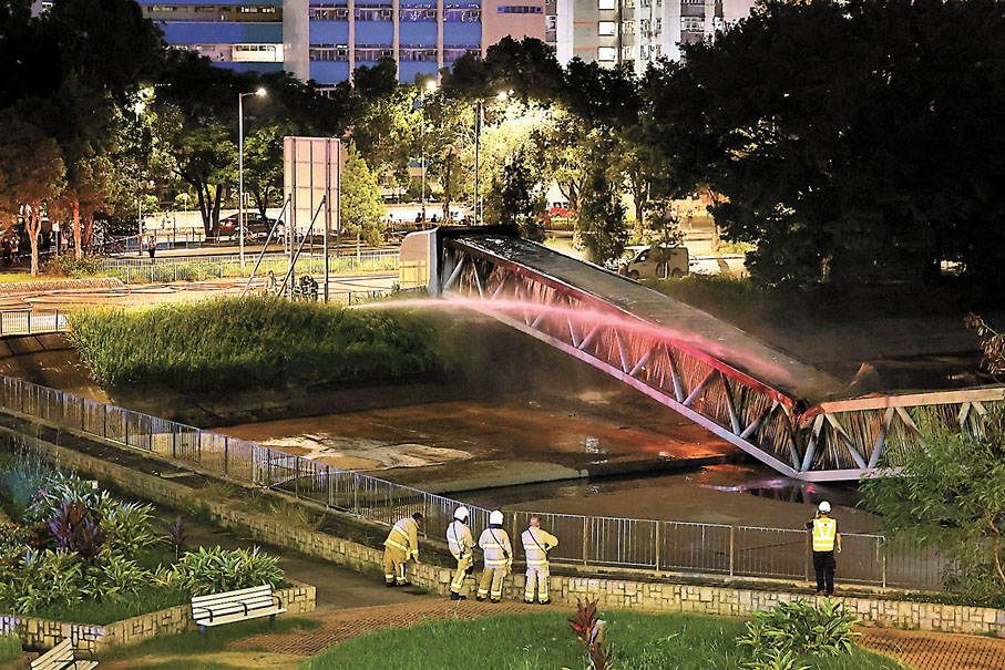◆火警中，輸電橋由中間斷裂下塌，消防員需不斷射水將火救熄。香港文匯報記者 攝