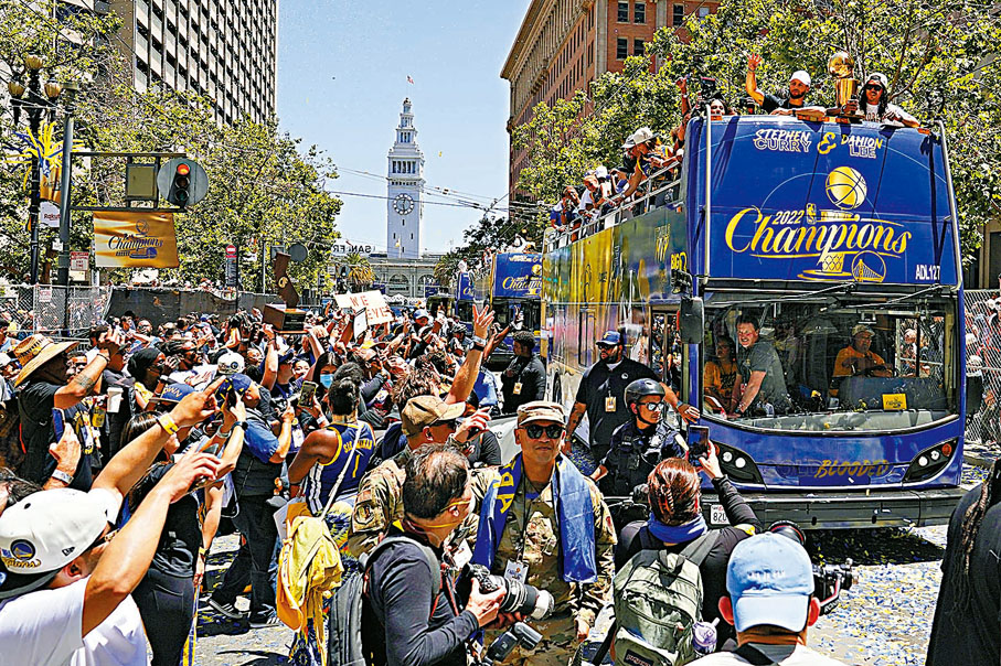 ◆ 勇士隊成員乘坐開篷巴士勝利巡遊，大批球迷夾道歡迎。  美聯社