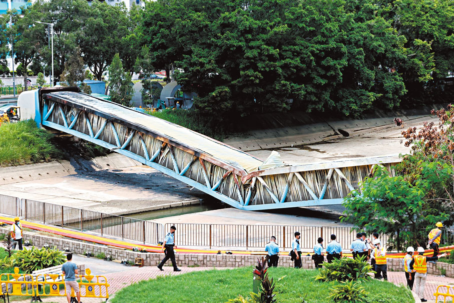 ◆在火警中燒至折斷坍塌的輸電橋，至昨日仍未清理，大批警員在現場調查。 香港文匯報記者  攝