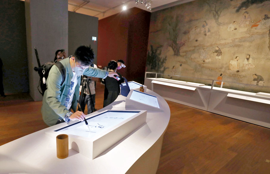 ◆ 觀眾體驗電子屏幕臨摹書法。 香港文匯報記者  攝