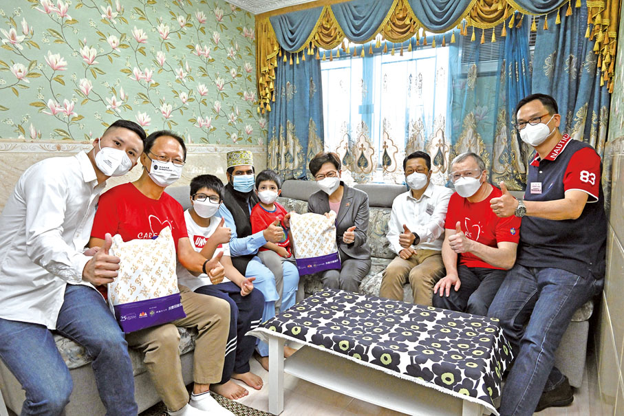 ◆ 行政長官林鄭月娥（右四）6月11日在署理民政事務局局長陳積志（右三）、黃大仙民政事務專員黃智華（左一）、香港賽馬會主席陳南祿（左二）和東九龍居民委員會主席何漢文（右一）陪同下探訪一個少數族裔家庭，了解他們的生活情況，並向他們派發禮物包