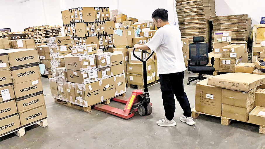 ◆黃鵬公司的工人在搬運貨品。