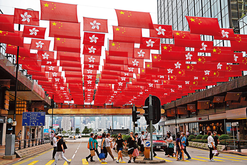 ◆香港街頭到處洋溢着慶回歸25周年的喜慶氣氛。 圖為尖東商業區的旗海成為市民打卡熱點。香港文匯報記者  攝