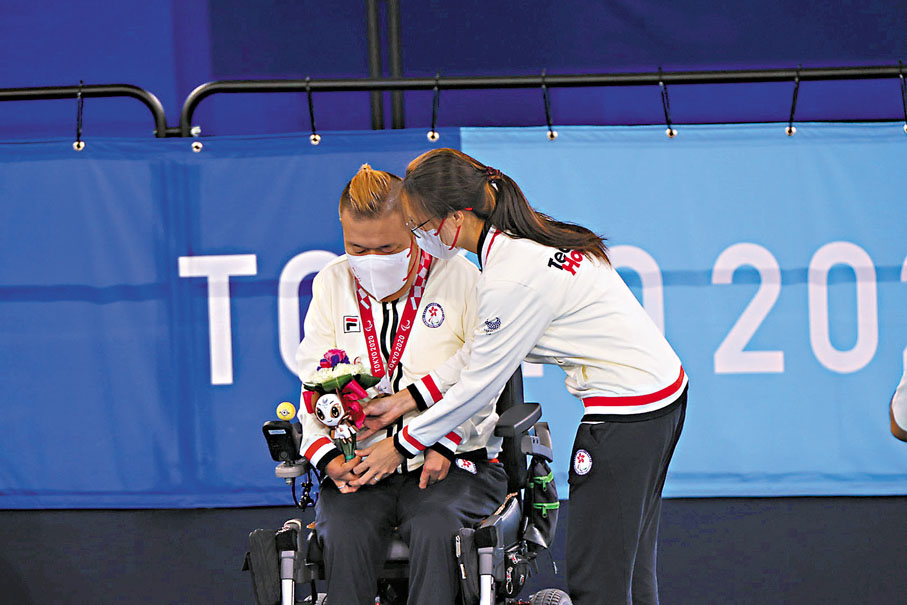 ◆妻子施珊珊親手為梁育榮掛上獎牌。 香港殘奧會圖片