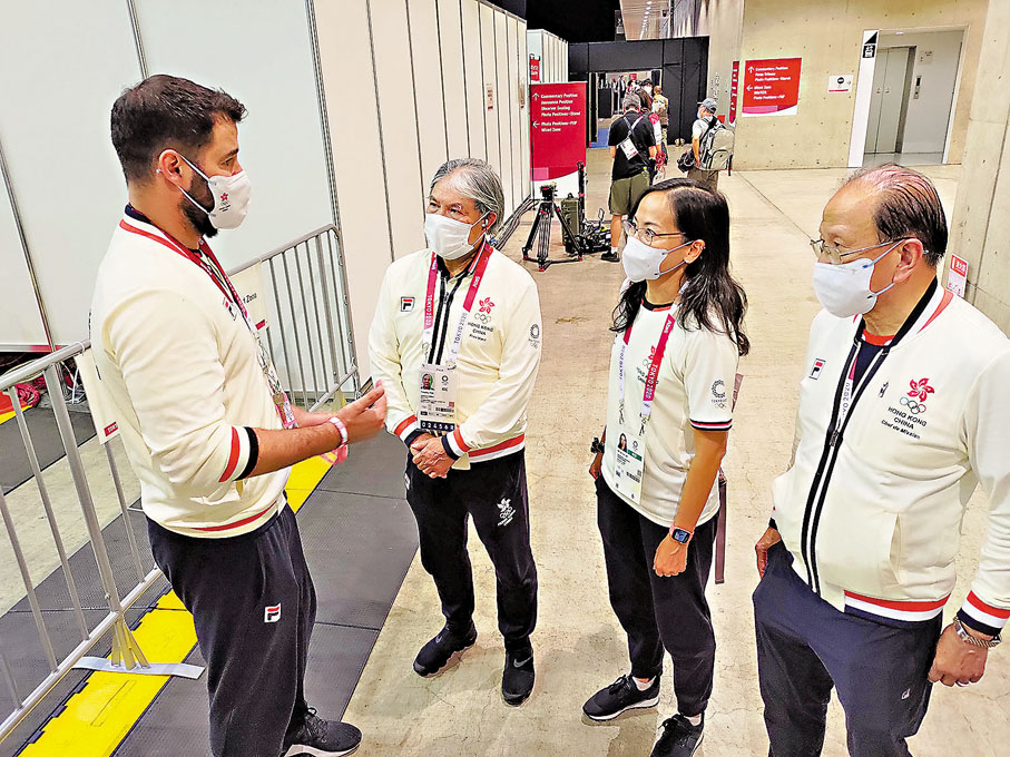 ◆霍震霆（左二）在東奧期間與港劍擊隊教練Gregory（左一）交流。資料圖片