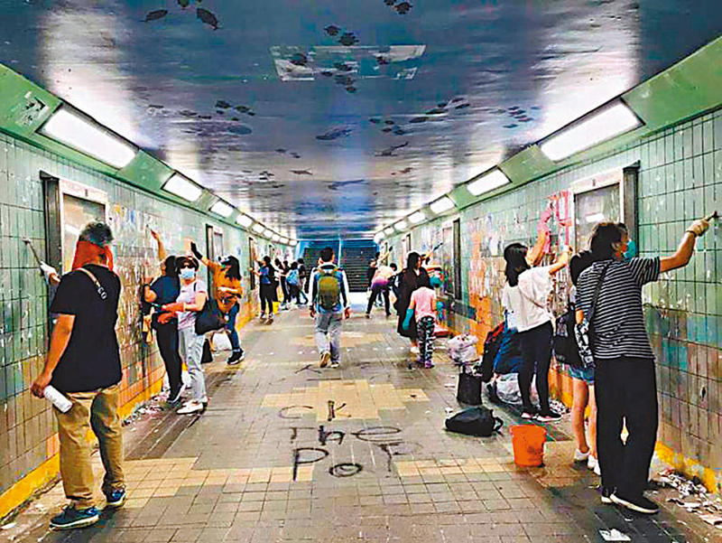 ◆黑暴肆虐期間，攬炒文宣在各區製造所謂「連儂牆」或「連儂隧道」。圖為市民清理文宣。 資料圖片