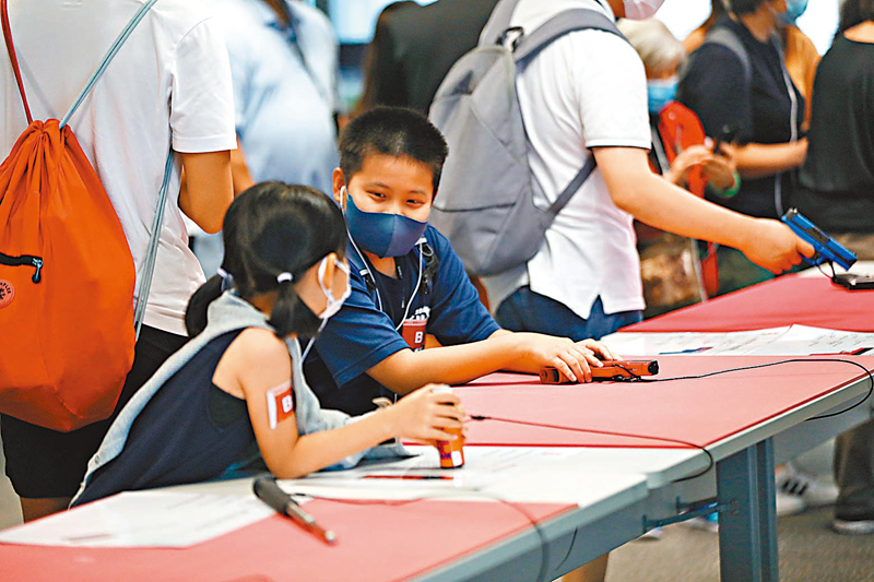 ◆令小朋友最興奮便是拿「真槍」上手。參觀當天展示多款現役或曾經使用的槍械，讓參觀者體驗一下做槍械組人員的滋味。 香港文匯報記者  攝