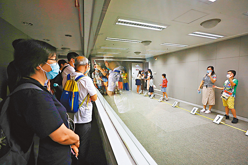 ◆令小朋友最興奮便是拿「真槍」上手。參觀當天展示多款現役或曾經使用的槍械，讓參觀者體驗一下做槍械組人員的滋味。 香港文匯報記者  攝