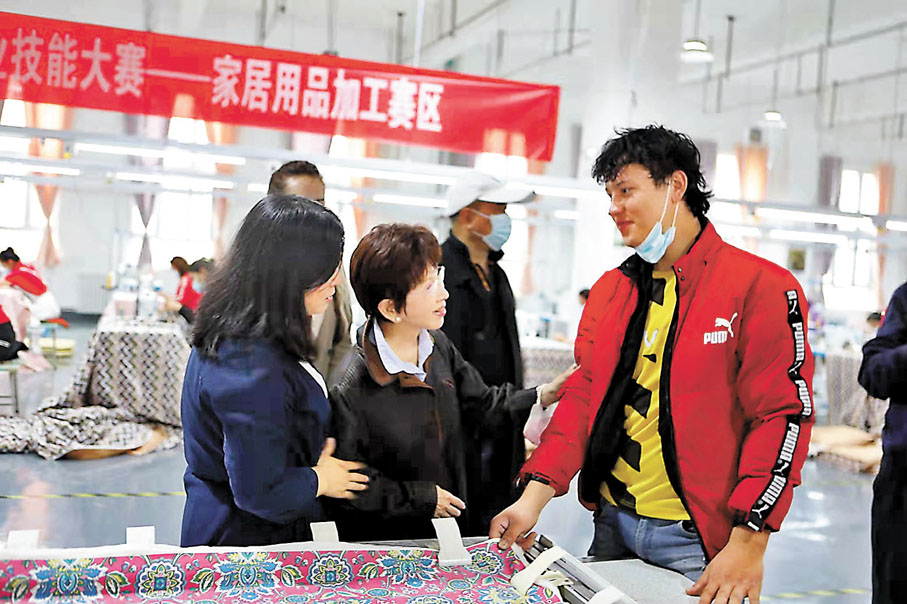 ◆洪秀柱（前中）在新疆伊寧紡織廠內與維吾爾族青年交談。