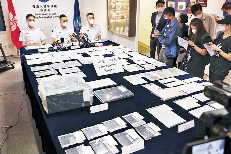 ◆ 入境事務處展示在偵破假結婚案中檢獲的大批文件。香港文匯報記者 攝