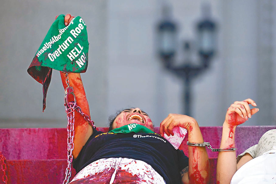 ◆在洛杉磯6日一場抗議中，支持墮胎權的示威者將自己淋上紅油，並戴上手銬，批評最高法院迫害女性。美聯社