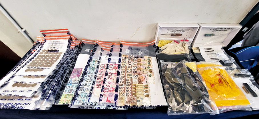 ◆警方檢獲的證物除大量現金外，另有賊人爆竊工具及犯案時穿的衣物。 香港文匯報記者 攝