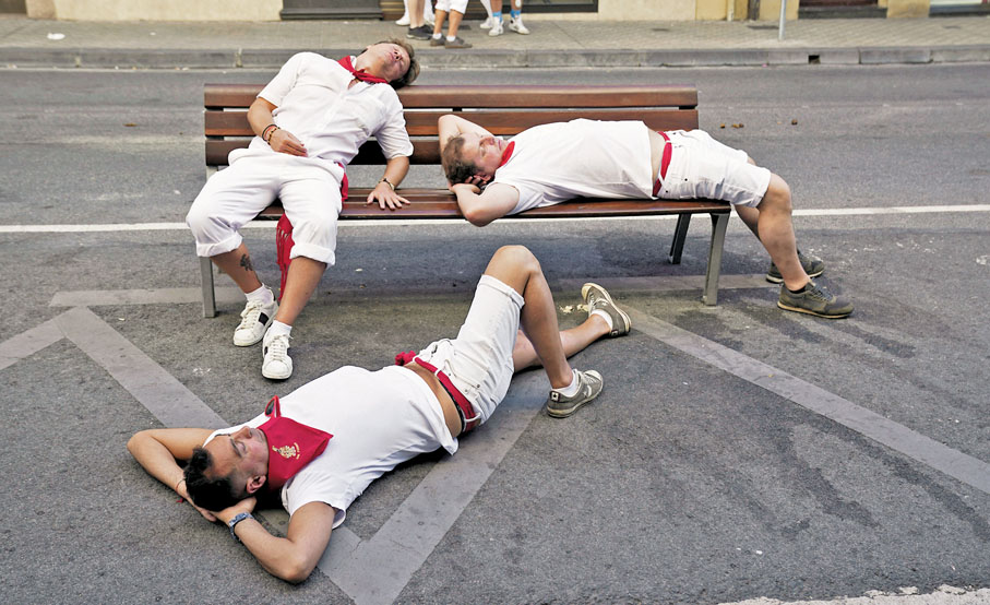 ◆參與當地派對的西班牙民眾在椅上休息。路透社