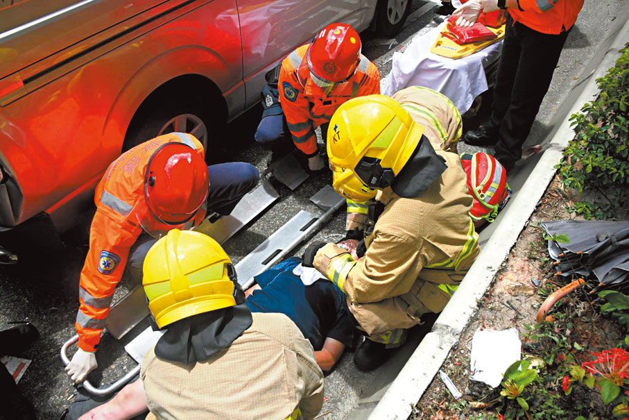 ◆消防員成功救出電單車男司機交救護車送院。