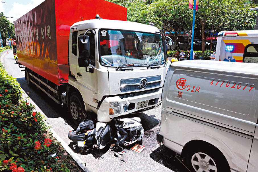 ◆車禍中，電單車遭貨車撞推撼向前方客貨車慘成三文治，釀一死一傷。香港文匯報記者 攝
