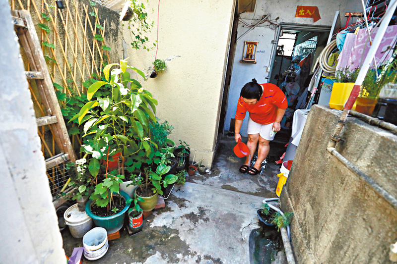 ◆區太難忍熱浪逼人,不時用凍水淋腳消暑。 香港文匯報記者 攝