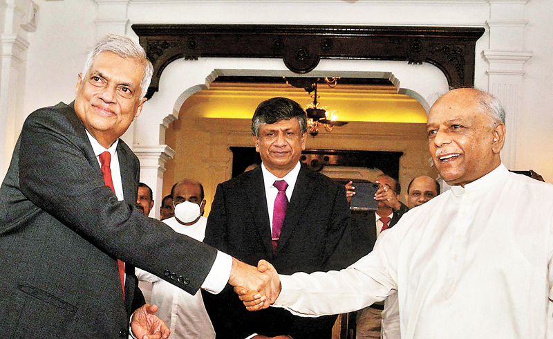 ◆ 拉尼爾．維克拉馬辛哈（左）與新任總理古納瓦德納握手。 路透社