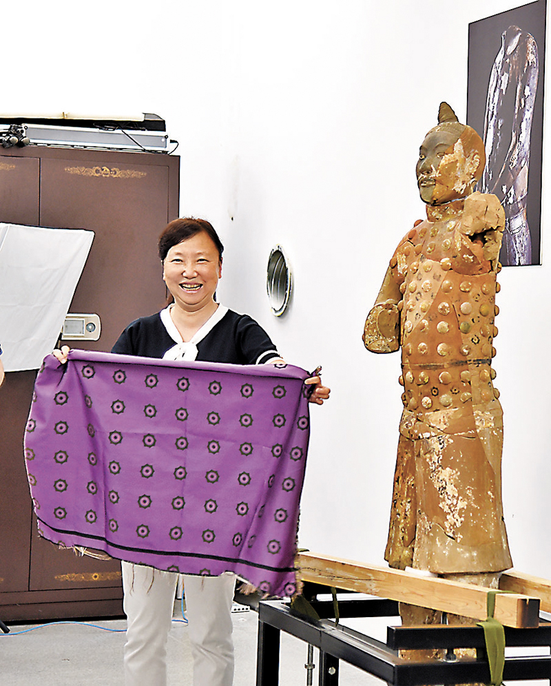 ◆「泡釘俑」上衣精緻。秦陵博物院副院長周萍正在展示復原的「泡釘俑」服飾材料。香港文匯報記者李陽波 攝