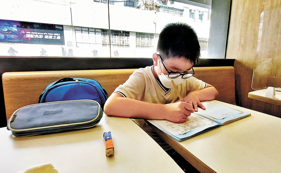 ◆9歲的Jason在麥當勞做功課。 香港文匯報記者 攝