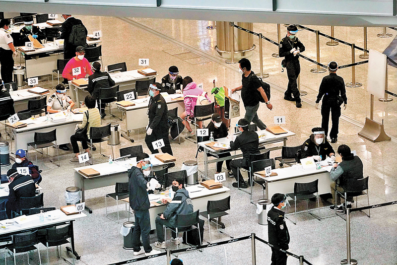 ◆盧寵茂表示，特區政府擬在「精準防疫」原則下放寬抵港檢疫措施。圖為抵達香港機場入境人士接受檢疫安排。 資料圖片