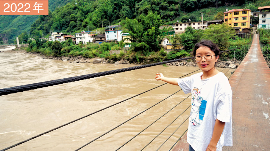 ◆ 余燕恰在橋上講述着小時候溜索上學的經歷。她手指方向為曾就讀的小學布臘小學。
