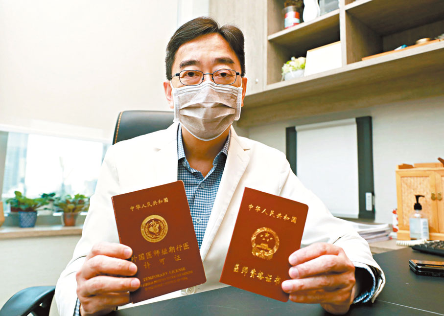 ◆高永文展示由內地簽發的「免試短期執業准許證」（左）及「無限期內地醫生執照」（右）。 香港文匯報記者  攝