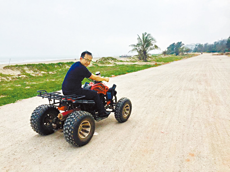 ◆徐志劍在廣東茂名騎沙灘車考察項目基地。
