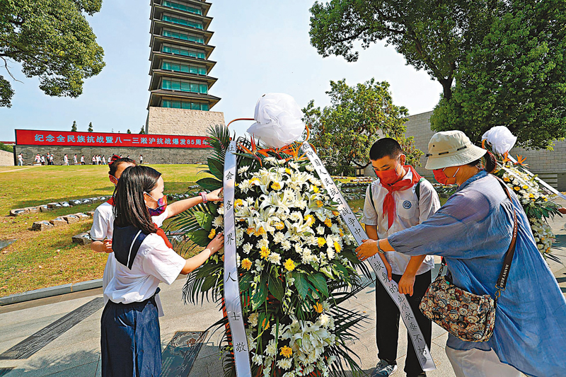 ◆紀念活動上，少先隊員向抗戰先烈敬獻花籃。  中通社