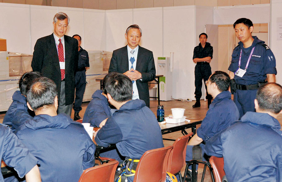 ◆2005年12月，時任保安局局長李少光視察世界貿易組織香港部長級會議保安區域的部署，為前線警員打氣。 資料圖片