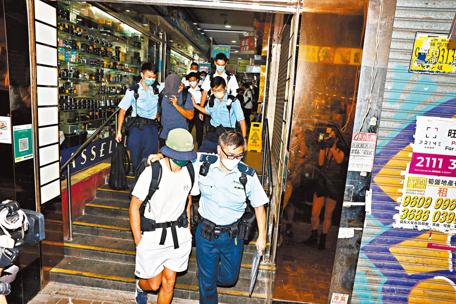 ◆警員將墮樓青年兩名好友帶署助查。香港文匯報記者 攝