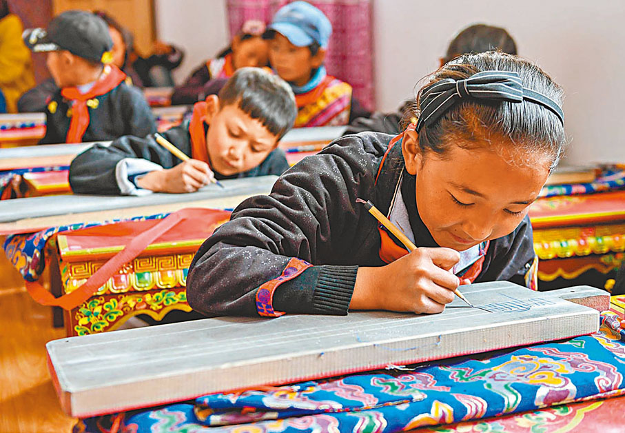 ◆西藏林芝市工布江達縣仲莎鄉中心小學低年級學生早前在藏文書法課上使用傳統工具練習藏文書寫。 資料圖片