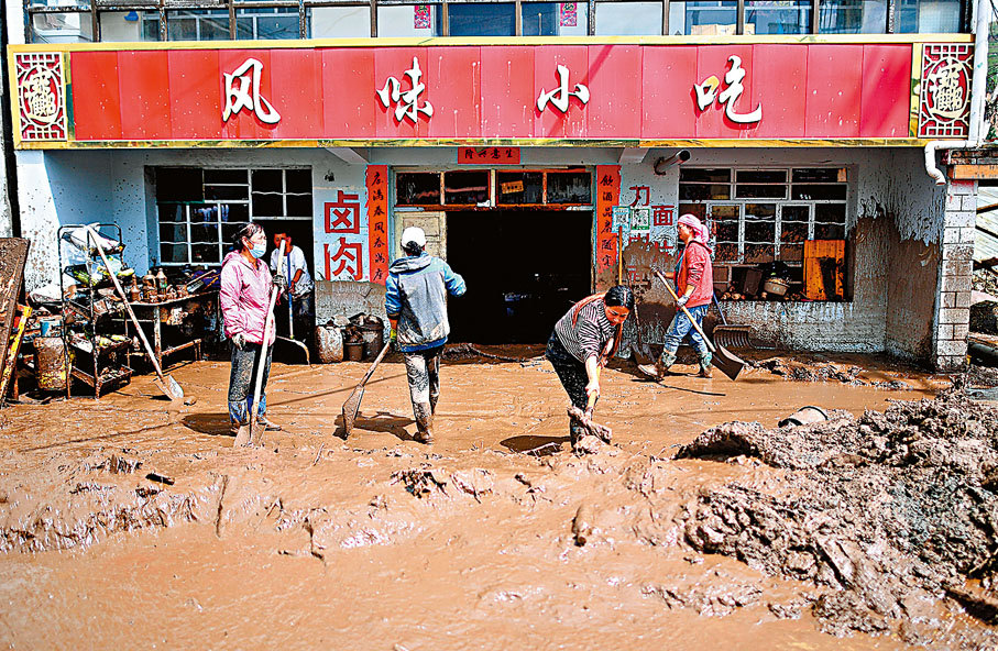 ◆青海省西寧市大通縣18日凌晨發生山洪災害。圖為受災群眾在青山鄉清理淤泥開展自救。目前當地已組織2,000多人投入現場搶險救災工作。 新華社