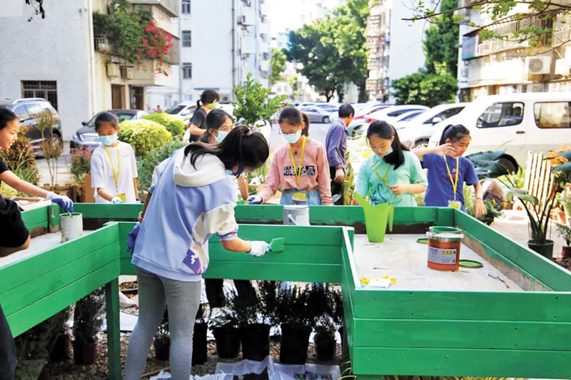 ◆ 鹽田區青少年書畫院鵬灣分院的師生正在為海漂木做成的柵欄塗色。 受訪者供圖